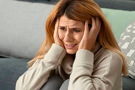 Женщина держится за голову